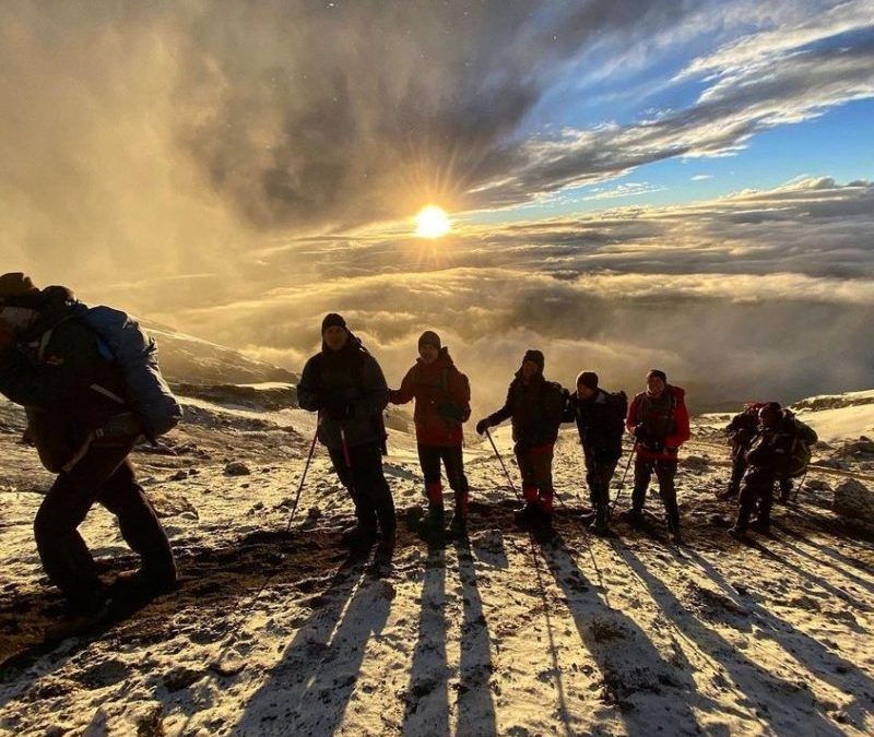 Climbers trekking towards the summit of Mount Kilimanjaro, showcasing the stunning landscapes and challenging terrain